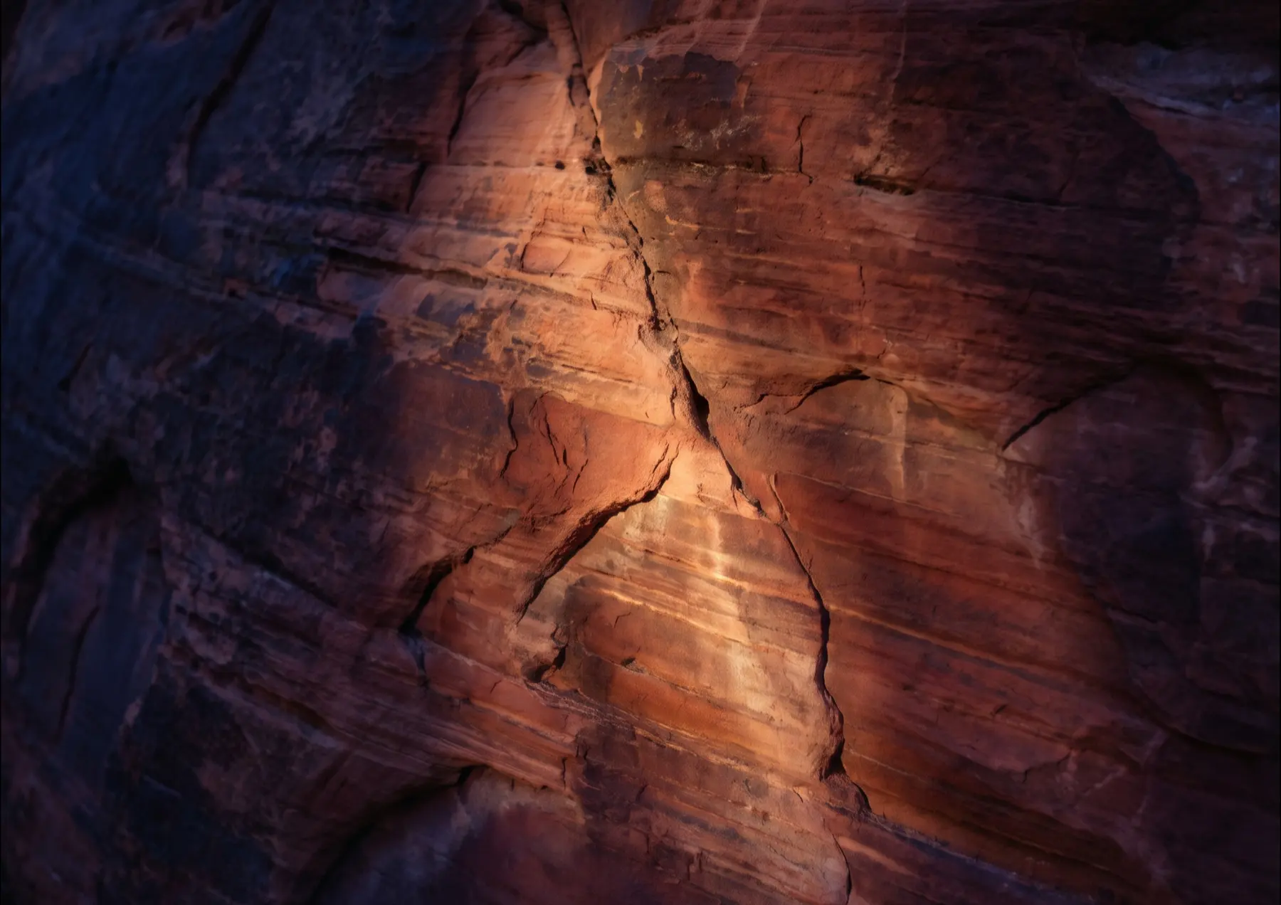 Sunlight raking across weathered red sandstone